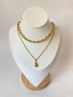 Portada Combo X2 Collares Rustik y Dije Gota Portada del set de dos collares de acero dorado para mujer, con el choker Rustik y el collar con dije de gota, exhibidos en un busto de joyería.
