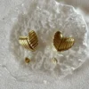 Cierre Aros Corazón Aros de corazón dorados mostrando el cierre de pin y tuerca de mariposa.