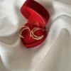 Aros Triple Argolla para Regalo Aros de triple argolla dorada dentro de un estuche de regalo rojo de terciopelo.