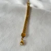 Detalle del Tejido de Malla Plana Macro del tejido de malla plana de la pulsera de acero quirúrgico dorada.