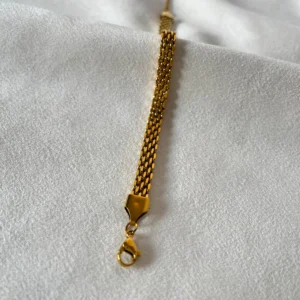 Detalle del Tejido de Malla Plana Macro del tejido de malla plana de la pulsera de acero quirúrgico dorada.