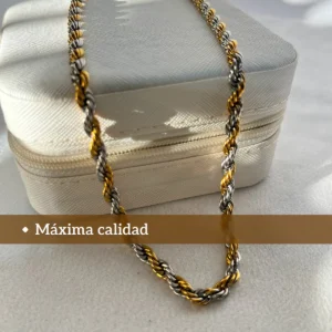 Máxima Calidad en Acero Quirúrgico Cadena tourbillon de acero bicolor sobre un joyero blanco de viaje.