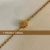 Máxima Calidad en Acero Quirúrgico Primer plano del dije de girasol de la pulsera dorada con un texto que dice "Máxima Calidad".