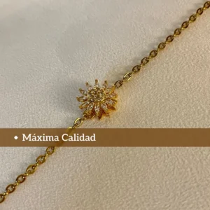Máxima Calidad en Acero Quirúrgico Primer plano del dije de girasol de la pulsera dorada con un texto que dice "Máxima Calidad".