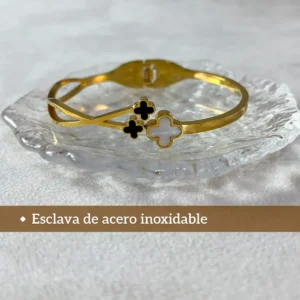 Diseño Moderno en Acero Inoxidable Pulsera esclava de acero inoxidable dorado con tréboles sobre una base de vidrio transparente.