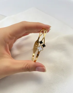Perfil del Diseño Cruzado de la Pulsera Mano de una mujer sosteniendo la pulsera de perfil, mostrando el diseño cruzado de la esclava.