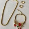 Set de Joyas Doradas Completo Set completo de joyas de acero dorado con collar tipo serpiente, pulsera con dijes de cereza y aros argolla.