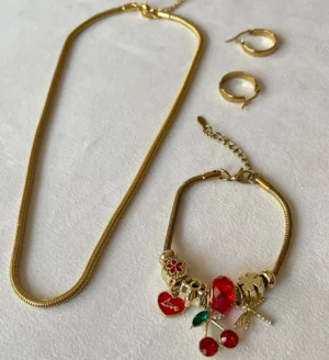 Set de Joyas Doradas Completo Set completo de joyas de acero dorado con collar tipo serpiente, pulsera con dijes de cereza y aros argolla.